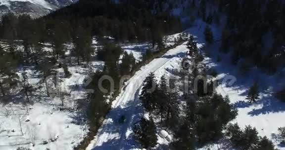 汽车沿着积雪覆盖的道路在山间行驶无人机的录像视频的预览图