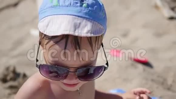 这孩子试着戴太阳镜海滩阳光明媚的热天视频的预览图