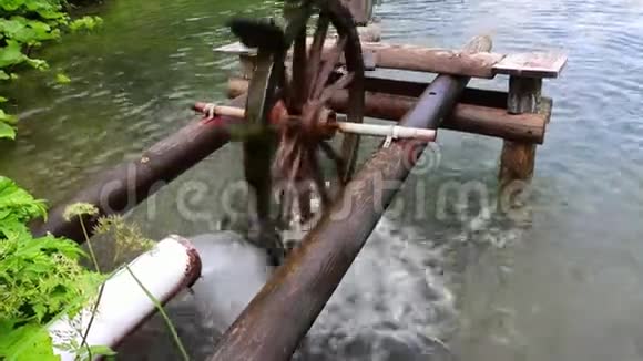 木制水轮在动力下转动水磨在池塘上视频的预览图