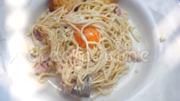 用意大利叉子吃意大利面食有帕尔马干酪蛋黄和培根慢动作1920x1080视频的预览图