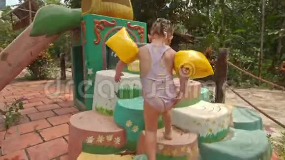 小女孩在游泳池的台阶上爬坡视频的预览图