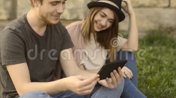 一个女孩和一个男人在公园里休息亲吻拥抱笑在太阳上视频的预览图