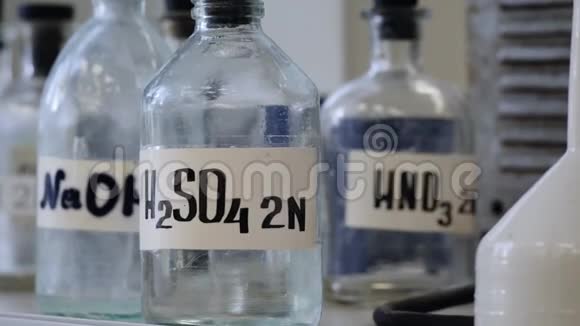 存放在实验室货架上的溶液瓶含有NaOHH2SO4和HNO3化学溶液的瓶子硫酸视频的预览图