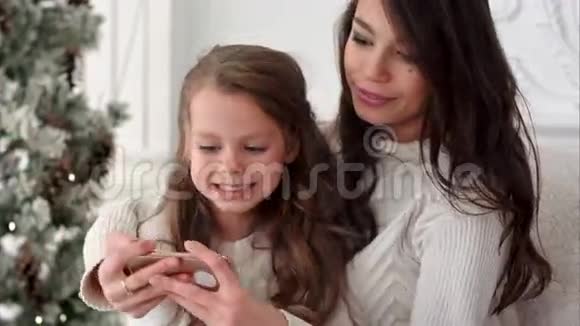 快乐的年轻母亲和她的女儿做圣诞快乐的自我和舌头视频的预览图