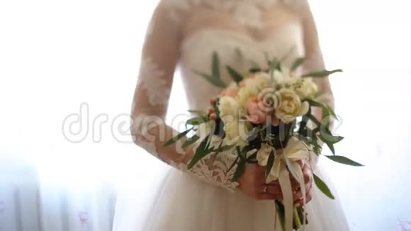 新娘的双手紧握着美丽的婚礼花束花束呈粉白色视频的预览图