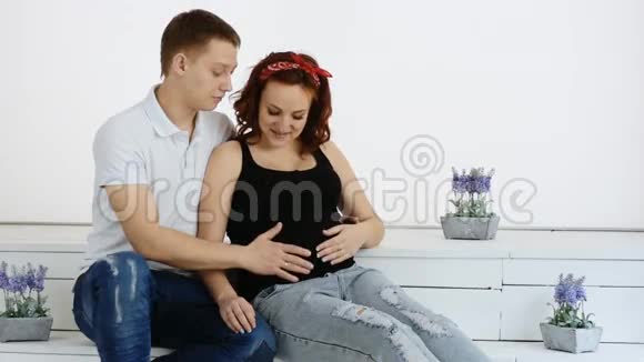 一个年轻成功的男人正在拥抱他怀孕的妻子慢动作视频的预览图