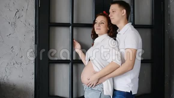 年轻漂亮的夫妇看着旁边站在他家门口视频的预览图