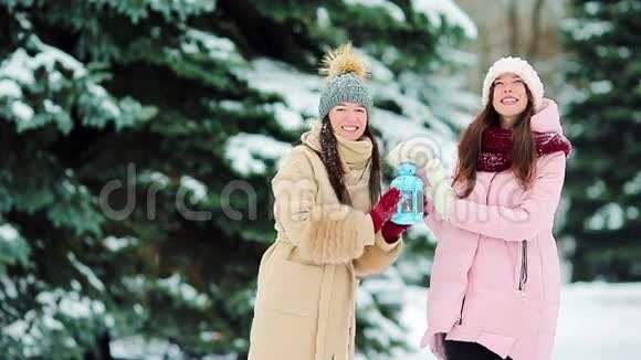 在美丽的冬雪日年轻女孩在户外手持圣诞烛光取暖视频的预览图