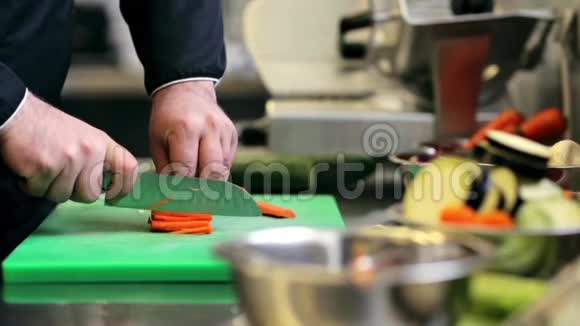 男厨师的手在厨房里切胡萝卜视频的预览图