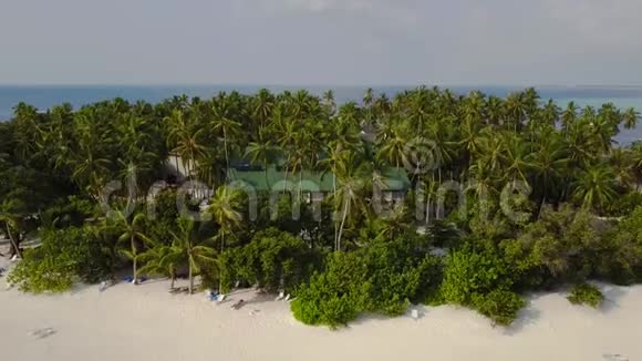 相机远离圆形热带环礁岛度假酒店酒店内有白沙棕榈树和绿松石印第安人视频的预览图