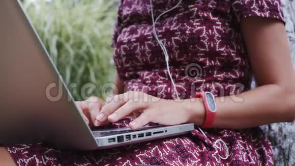 带着笔记本电脑在草地上工作的女人视频的预览图