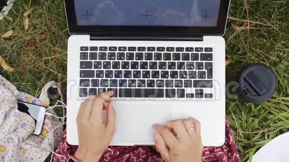 带着笔记本电脑在草地上工作的女人视频的预览图