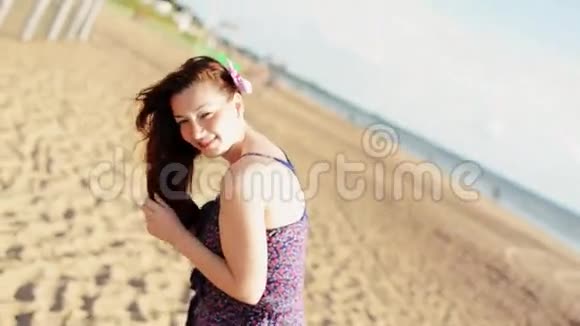 快乐的年轻女孩在海滩上跳舞在镜头中微笑晴天无忧无虑人民视频的预览图