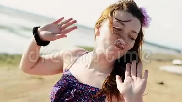 快乐的年轻女孩在海滩上跳舞在镜头中微笑晴天骑自行车的人视频的预览图