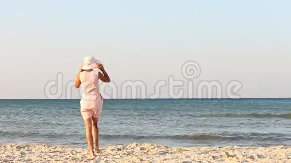 海滩上戴帽子的女孩视频的预览图