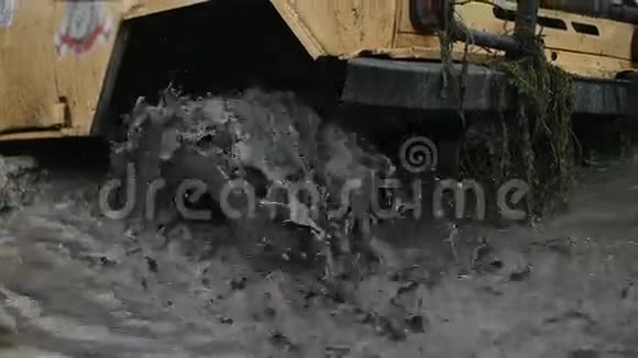 一个车轮卡在脏水和泥泞中的特写镜头轮子在转但它无能为力视频的预览图