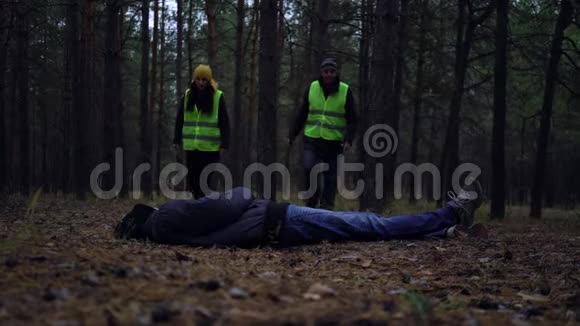 一群身穿绿色背心的志愿者在松林中寻找失踪人员视频的预览图