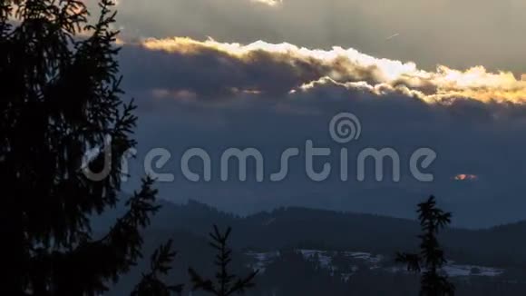 太阳升起在云层上森林景观在冬季消失清晨树木随风移动视频的预览图