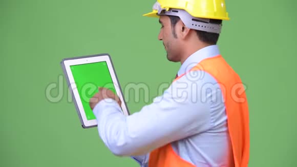 年轻英俊的波斯建筑工人展示数字平板电脑视频的预览图