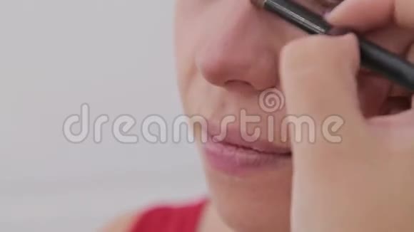 近距离射击化妆师在性感模特的脸上化妆视频的预览图