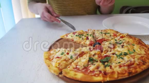 女孩的手切一片披萨把它放在咖啡馆的盘子里多利射击视频的预览图