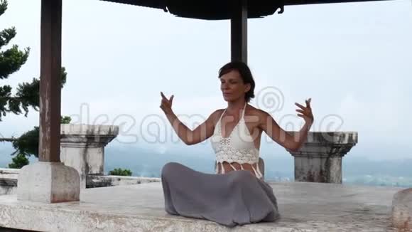 女人在废弃的寺庙里冥想和做瑜伽女性练习姿势视频的预览图