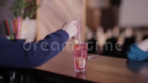 酒保把一根吸管放进装有鸡尾酒的杯子里然后传送给客户视频的预览图
