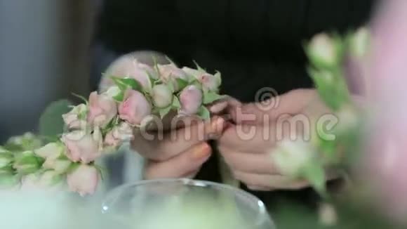 皇冠上的许多小玫瑰花匠的手特写视频的预览图
