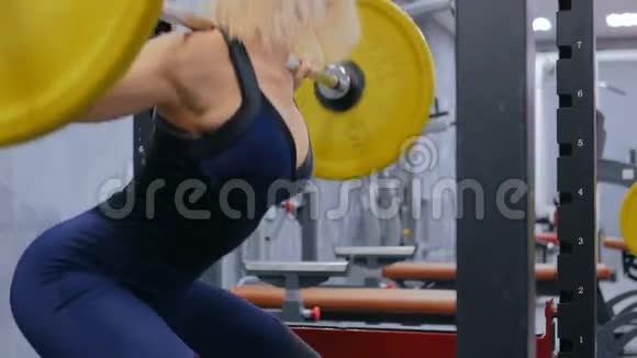 运动的年轻女子在健身房用杠铃做运动视频的预览图