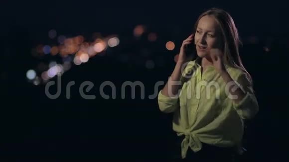 快乐的女人在晚上用手机说话视频的预览图