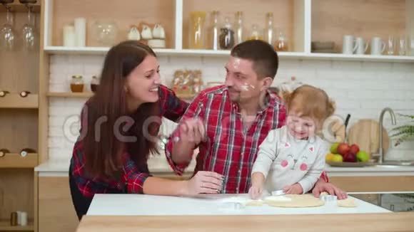 三个幸福的家庭一起在厨房玩视频的预览图