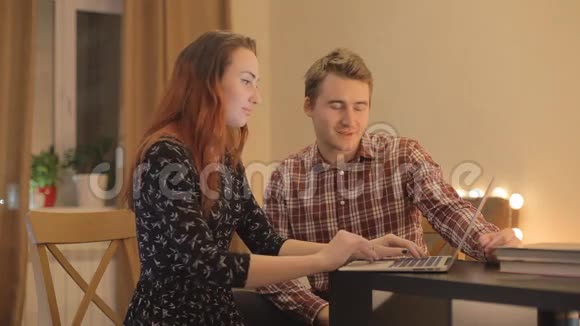 年轻夫妇在讨论网络购物笔记本电脑视频的预览图