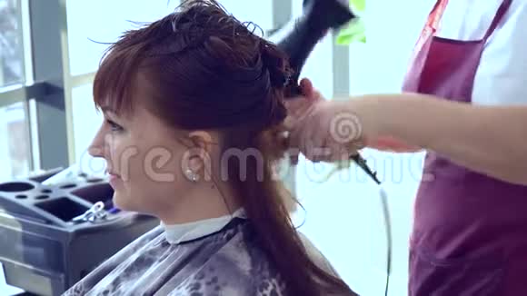 美容院理发店斯特里斯特把头发给他的客户特写镜头视频的预览图