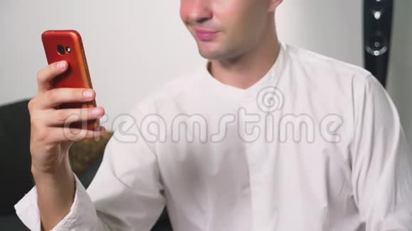 男人用智能手机上的视频调情这家伙在使用智能手机的视频通话中在线发送一个吻视频的预览图