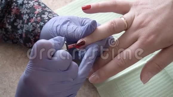 专家用红色LEDUV凝胶指甲油覆盖客户的指甲关门视频的预览图