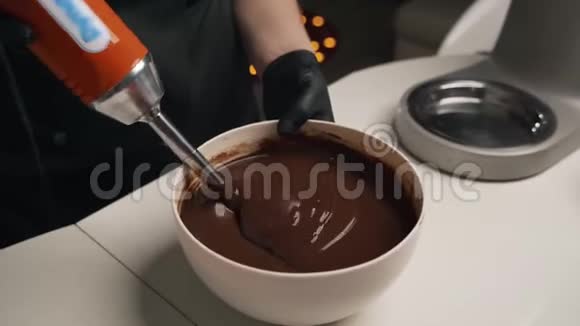 穿黑色制服的女糖果师为巧克力慕斯蛋糕准备奶油舞台烹饪摩丝蛋糕视频的预览图