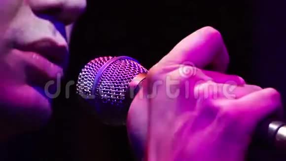在音乐会上男歌手用麦克风演唱歌曲视频的预览图