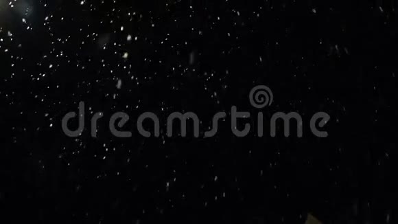 许多雪花从天空飘落在黑色的背景上视频的预览图