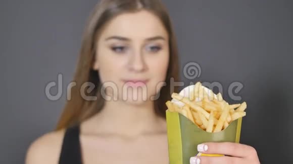 年轻女性吃炸薯条的细节视频的预览图