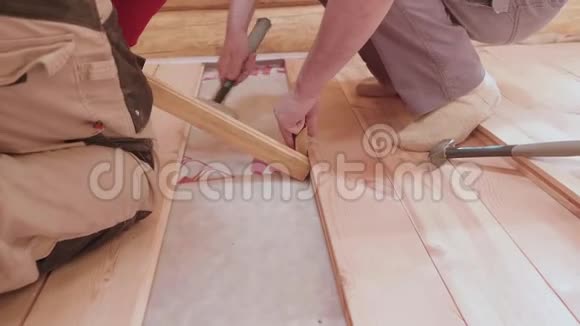 木匠在房子里用木板紧紧地铺衬里地板视频的预览图