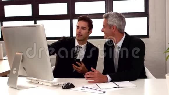 商人说话和指着电脑显示器视频的预览图