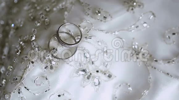 白色花边背景上的结婚戒指视频的预览图