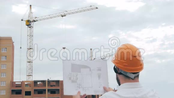 施工现场总建筑师总建筑师戴着安全帽在施工现场看方案蓝图视频的预览图