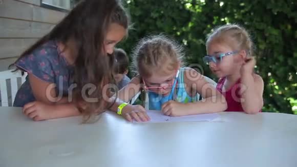 女孩在户外的桌子上画铅笔视频的预览图