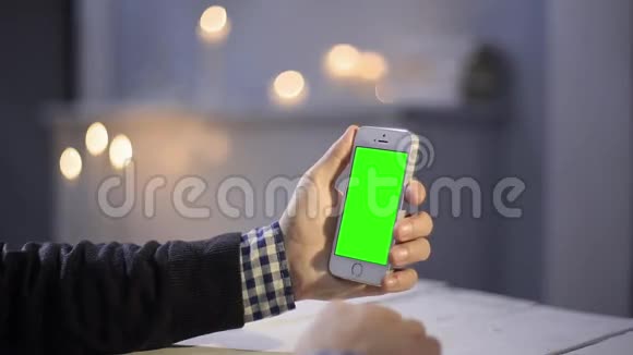 在木桌上使用智能手机各种手势垂直关闭绿色屏幕视频的预览图