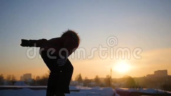 青少年在冬天在游乐场玩日落时分在雪地里翻腾视频的预览图