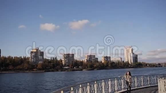 悲伤的美丽女孩走在桥上秋城的背景中柔和的光视频的预览图