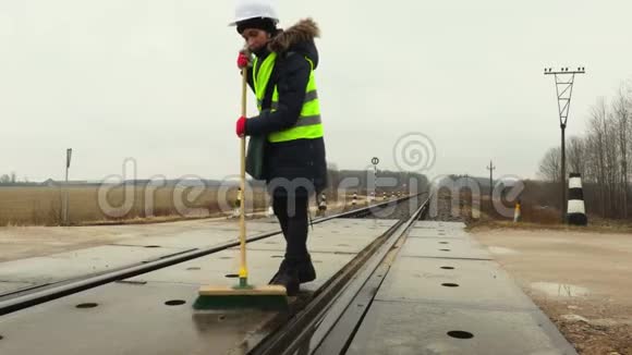 女铁路工人冬季清洁铁路道口视频的预览图
