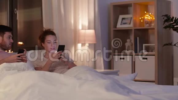 晚上在床上用智能手机的情侣视频的预览图