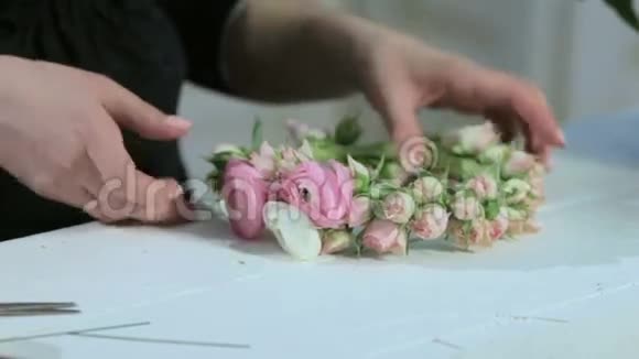 花商展示白色桌子上的小玫瑰皇冠视频的预览图